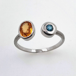 Anillo de oro blanco 18KT de Garnet Spessartite y diamante azul.