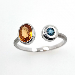 Ring aus 18KT Weißgold mit Granat, Spessartit und blauem Diamant.